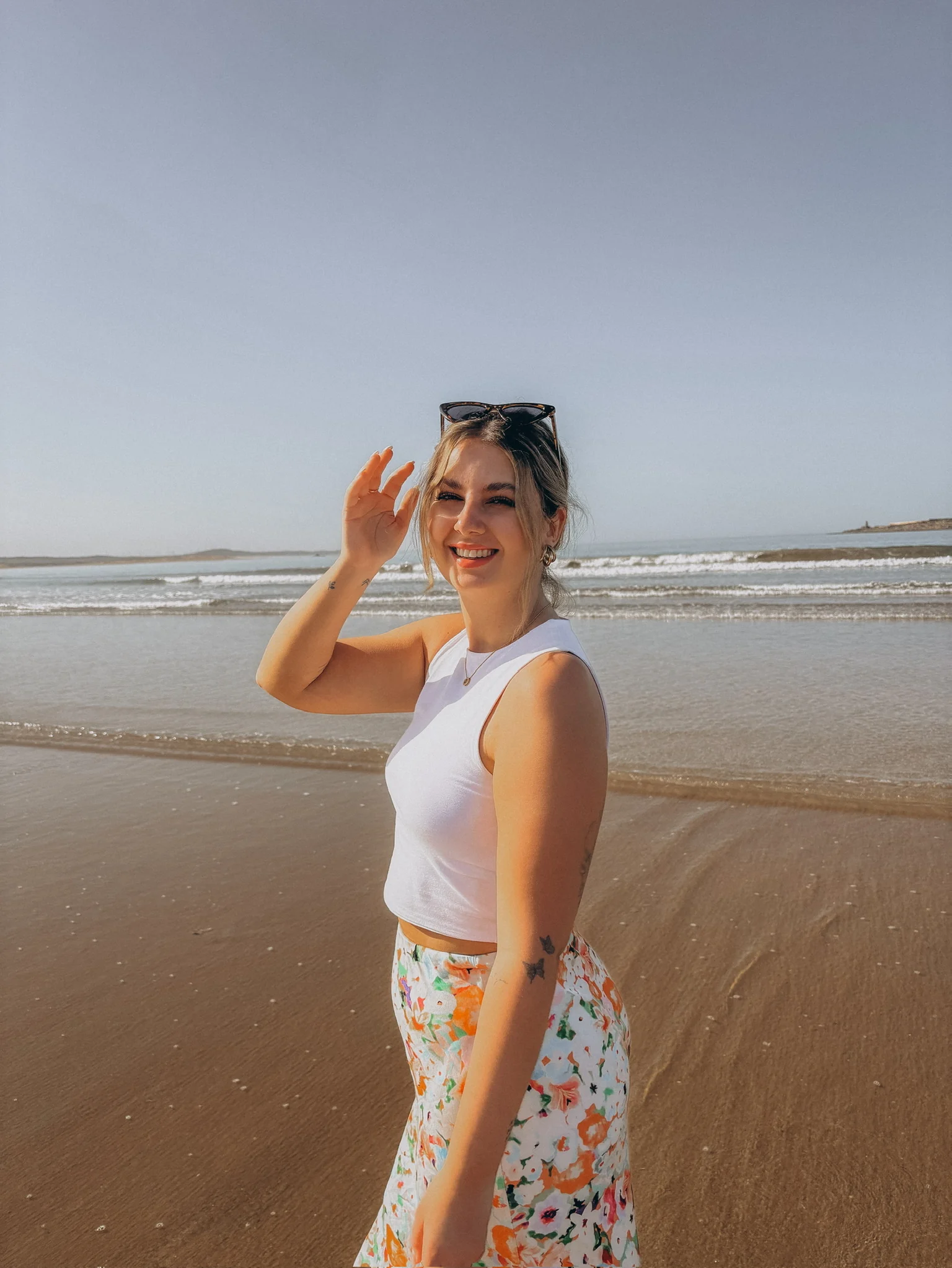 Vanessa Böttger am Strand, die Hand zum Gruß an der Stirn